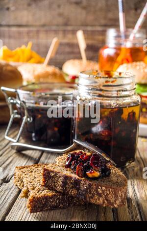 Hausgemachte Speck Marmelade in Gläsern, mit Brot und Burger Stockfoto