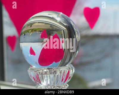 Herzen im Fenster reflektiert in Glaskugel Stockfoto