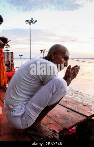 Indien, Varanasi - Bundesstaat Uttar Pradesh, 31. Juli 2013. Ein frommer Mann betet vor dem Ganges bei Sonnenaufgang. Stockfoto