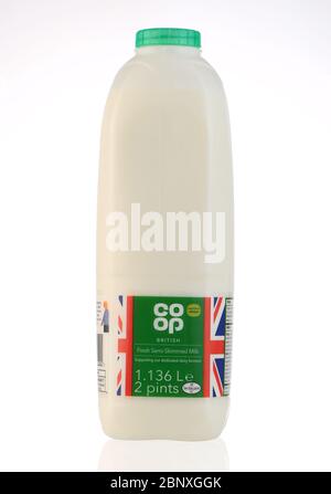 Co-op-Milchflaschen aus Kunststoff isoliert vor weißem Hintergrund mit einer Reflexion. Eine Flasche fettarme, halbfettarme grüne Deckelmilch. Stockfoto