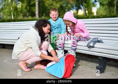 Mutter legt Kinder auf ihre Füße Rollschuhe in St. Petersburg Stockfoto