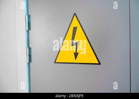 Schild für hohe Spannung an der Metalltür. Nahaufnahme Stockfoto