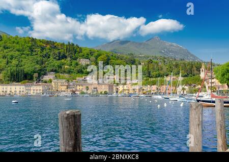 Ein idyllischer Blick auf die kleine Stadt von einem kleinen Hafen an der Anlegestelle am Gardasee Stockfoto