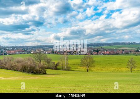 Eine Landschaft mit Wiesen und Feldern im Hintergrund sind drei Wolkenkratzer. Der Himmel wird durchzogen Stockfoto