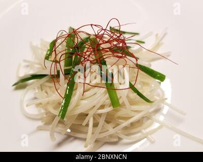 Bohnensprossen-Salat, bestehend aus gebratenen Bohnensprossen, Schnittlauch und straffer roter Paprika auf weißem Hintergrund Stockfoto