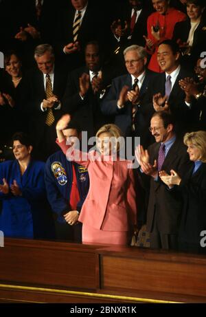 Hillary Clinton winkt, nachdem sie von Präsident Bill Clinton anerkannt wurde, bevor sie die Rede zur Lage der Union vor dem Kongress am 27. Januar 1998 in Washington, D.C. ablieferte. Sie steht mit der ersten Dame von links nach rechts: Elaine Kinslow, Kommandant des Space Shuttle Col. Robert Cabana, Dr. Harold Varmus, Direktor der National Institutes of Health, und Tipper Gore. Stockfoto