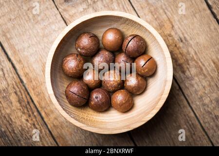 Getrocknete Bio-Macadamia-Nüsse in Holzschale Nahaufnahme. Makroaufnahmen in Studio. Food-Fotografie Stockfoto