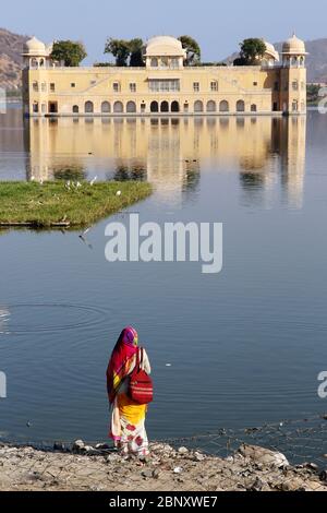 Rajasthani Frau in wunderschönem Sari beobachten den berühmten Palast am See in Jaipur Stockfoto