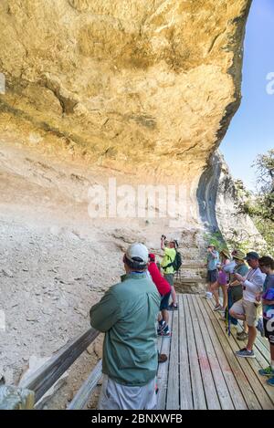 Touristen, die die verschiedenen Navajo Wandmalereien im Fate Bell Shelter, im Seminole Canyon, Texas, betrachten Stockfoto