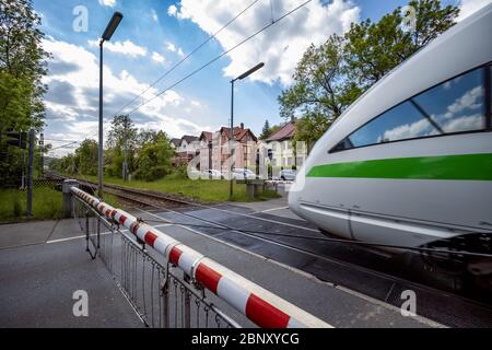 Deutscher ICE-Zug, der einen eingeschränkten Bahnübergang passiert Stockfoto