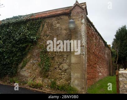 Appuldurcombe Park Walled Garden - wo die Mauer auf Sicht von der Zugehungsstraße mit einer Steinplatte aufgepflastert ist Stockfoto