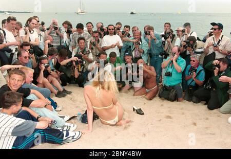 CANNES, FRANKREICH. Mai 1997: Fotografen drehen ein Starlet am Strand bei den 50. Filmfestspielen von Cannes. Foto © Paul Smith/Featureflash Stockfoto