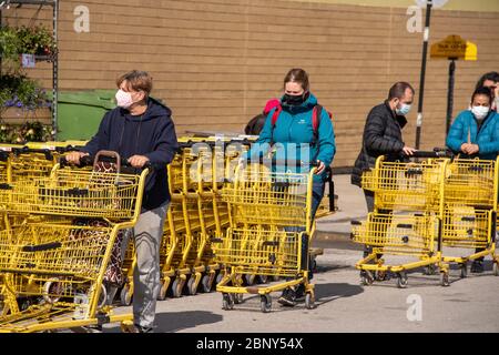 Montreal, CA - 16 May 2020 : Kunden in einer Linie außerhalb des Supermarktes. Einige von ihnen tragen Covid-19 Schutzmasken. Stockfoto