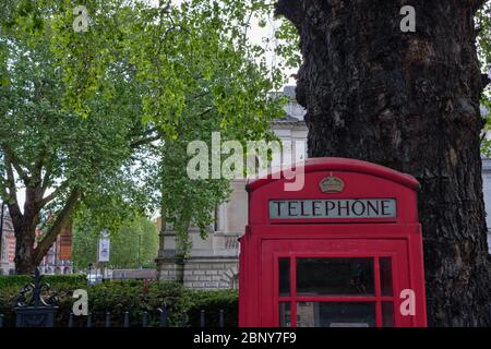 London, Großbritannien - 12. Mai 2020: Die Spitze der britischen roten Telefondose in London vor Bäumen Stockfoto