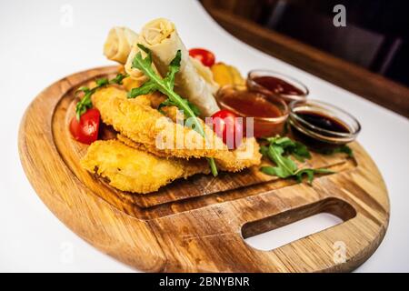 Frische Frühlingsrollen mit panierten frittierten Käse und würzigen Saucen Stockfoto