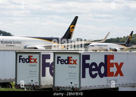 FedEx Express LKW Anhänger sind vor einem United Parcel Service UPS Airlines Flugzeug in Middletown, Pennsylvania am 4. Mai 2020 gesehen. Stockfoto