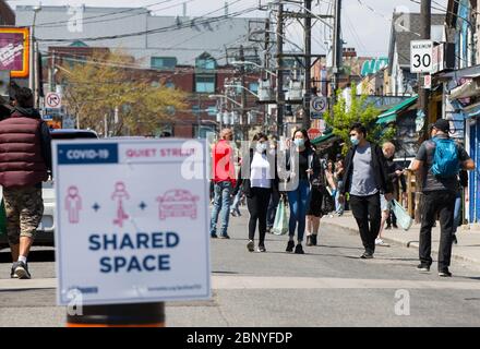 Toronto, Kanada. Mai 2020. Menschen mit Gesichtsmasken gehen am 16. Mai 2020 in Toronto, Kanada, entlang einer Straße. Die Stadt Toronto verwandelte Abschnitte auf Hauptstraßen in „ruhige Straßen“, um mehr Platz für die Menschen zu bieten, um körperlich aktiv zu sein und die körperliche Distanz zu verbessern, da der COVID-19-Ausbruch am langen Wochenende ausbrach. Kredit: Zou Zheng/Xinhua/Alamy Live News Stockfoto