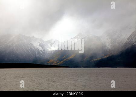 WYOMING - Blick auf die schneebedeckte Teton Range vom Coulter Bay Lakeshore Trail auf Jackson Lake bei einer kurzen Schneedusche im Grand Teton Natl Park Stockfoto