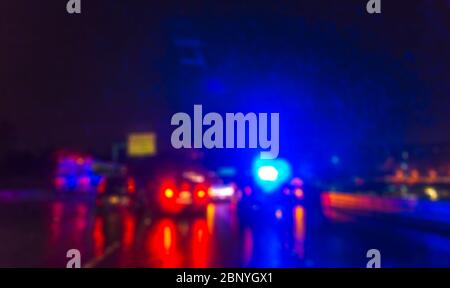 Beleuchtung des Polizeiautos in der Nacht während eines Unfalls auf der Straße bei Regen. Stockfoto