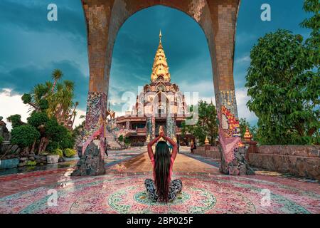 Junge schöne Mädchen meditiert in einem buddhistischen Tempel auf dem Hintergrund der schönen Natur. Stockfoto