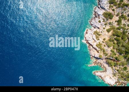 Helles klares Meerwasser und felsige Küste von oben nach unten Luftaufnahme. Stockfoto