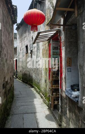 Eine rote chinesische Laterne hängt vor einem kleinen Laden in der alten Stadt Hongcun in China. Stockfoto