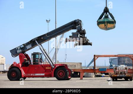 Großer Container-Handler und Clamshell-Bucket an einem lokalen Port. Stockfoto