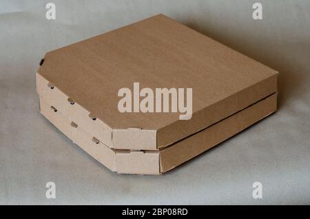 Pappkartons für Pizza Nahaufnahme. Zwei geschlossene braune Kisten in einem Stapel. Verpackung und Lieferung von Lebensmitteln. Kurierdienst. Nahaufnahme. Selektiver Fokus. Stockfoto