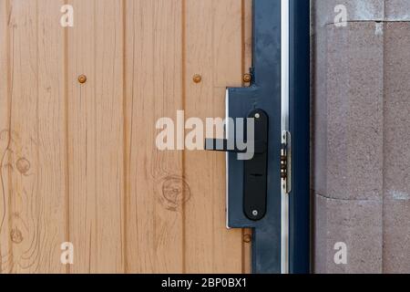 Detail einer geschlossenen Tür mit einem Schloss Griff.Metallgriff und Schloss an der Haustür. Stockfoto