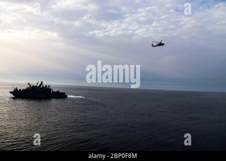 200506-A-UQ166-0130 ARABISCHER GOLF (6. Mai 2020) EIN MH-60S Seahawk-Hubschrauber fliegt über ein Mark VI Patrouillenboot, das an die Kommandant der Task Force (CTF) 56 im Arabischen Golf, 6. Mai 2020, angeschlossen ist. CTF 56 ist für die Planung und Durchführung von Expeditions-Missionen einschließlich Küstenflußeinsätzen im 5. Einsatzgebiet der US-Flotte verantwortlich. (USA Armeefoto von SPC. Cody Rich) Stockfoto