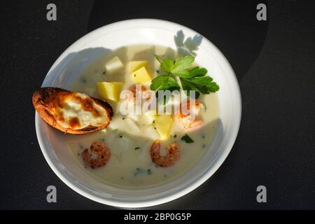 Spargelcremesuppe mit Shrimps und Knoblauchbrot Stockfoto
