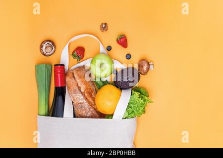 Verschiedene Lebensmittelwaren in Leinenbeutel auf rosa Hintergrund, Draufsicht. Stockfoto