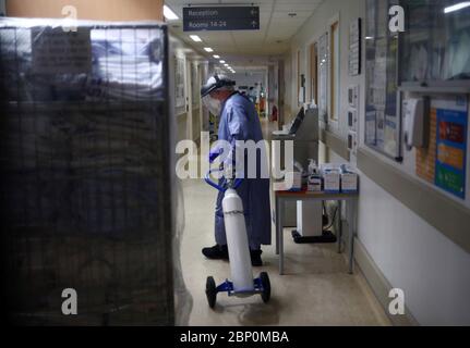 Ein Mediziner verlegt während des Ausbruchs der Coronavirus-Krankheit einen Sauerstofftank in der Intensivstation des Royal Blackburn Teaching Hospital in East Lancashire. Stockfoto