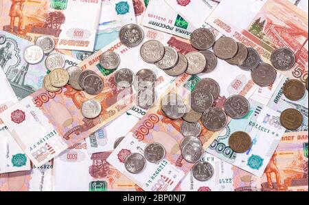 Der Hintergrund der Banknoten der Rubeln, die auf der Oberfläche mit dem Los der Münzen liegen Stockfoto