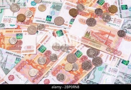 Der Hintergrund der Banknoten der Rubeln, die auf der Oberfläche mit dem Los der Münzen liegen Stockfoto