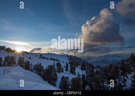 Sonnenuntergang hinter den Bergen im Skigebiet Belle Plagne in Savoie, Frankreich Stockfoto