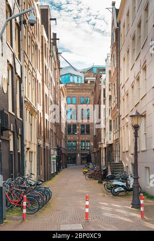 Typische enge Straße in Amsterdam mit Tanzhäusern und Fahrrädern, Niederlande. Stockfoto