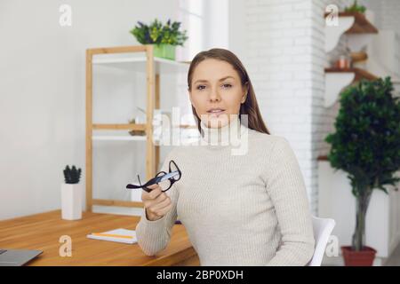 Online-Beratung für Unternehmen. Eine Geschäftsfrau in Freizeitkleidung schaut die Kamera eine Video-Chat-Konferenz Gespräch mit ihrem Partner aus der Ferne verwenden Stockfoto