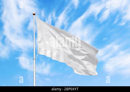 Leere weiße Flagge auf der Stange winken im Wind im Hintergrund des bewölkten Himmels. Bunte Outdoor-Bild mit leeren Flagge Mockup Stockfoto