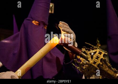 Nazarene zündet Kerze an einer heiligen Woche an Stockfoto