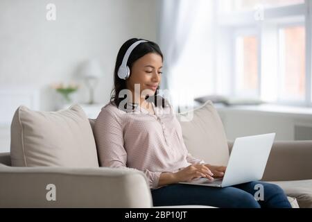 Afrikanische Frau mit Kopfhörern Tippen Nachricht mit Computer Stockfoto