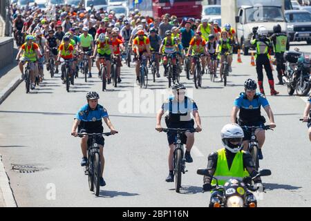 Kiew, Ukraine - 01. Juni 2019:Polizisten auf Fahrrädern führen eine Gruppe von Radfahrern bei einer Radtour in Kiew, Ukraine Stockfoto