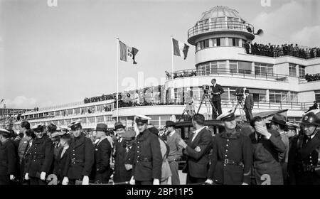 August 1937. Vintage Schwarz-Weiß-Foto mit dem Istres-Damaskus-Paris Air Race. Es wurde vom Aero Club de France organisiert. Das Rennen hatte 22 Teilnehmer, aber nur 13 starteten das Rennen, und 9 absolvierten die Strecke. Die Italiener Ranieri Cupini & Amadeo Paradisi siegten in ihrem Savoia-Marchetti S-79. Das Foto zeigt Menschenmassen vor dem Flughafenterminal und einen Mann mit einer Fernsehkamera auf einer erhöhten Plattform, der das Ereignis filmt. Stockfoto