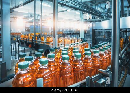 Förderband, Saft in Flaschen, Interieur der Getränkeherstellung in blauer Farbe, industrielle Produktionslinie. Stockfoto