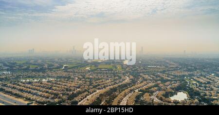 Luftbild Dubai Panorama mit Villen und Häuser von Anwohnern im Vordergrund und Hochhäuser Wolkenkratzer Gebäude in der Morgendämmerung im Hintergrund, vereinen Stockfoto