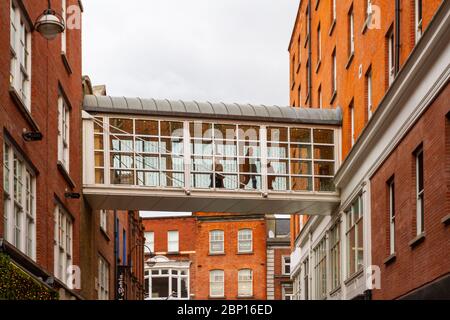 Skyway, Skybridge oder Skywalk zwischen zwei Gebäuden in Dublin. Leute, die durch einen geschlossenen Pedway zum 'Brown Thomas' Kaufhaus laufen. Irland Stockfoto