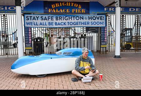 Brighton UK 17. Mai 2020 - dieser Radfahrer hält für eine Pause und einige Fish & Chips am Brighton Palace Pier, nachdem er heute an einem warmen Tag mit einer Mischung aus Sonnenschein und Wolken am ersten Wochenende nach der leichten Regierung von South London mit seinem Velomobil abfährt Lockdown-Beschränkungen in England während der COVID-19-Pandemie des Coronavirus . Quelle: Simon Dack / Alamy Live News Stockfoto