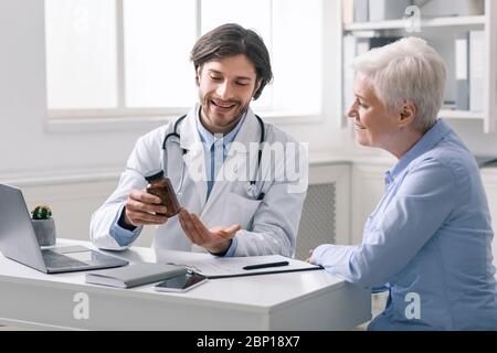 Höflicher Arzt verschreibt der älteren weiblichen Patientin Medikamente Stockfoto