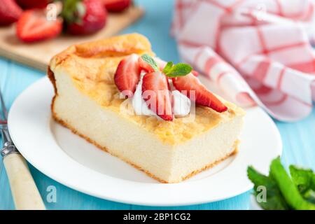 Quark-Auflauf mit Erdbeeren und Sahne auf blauem Hintergrund, Nahaufnahme Stockfoto