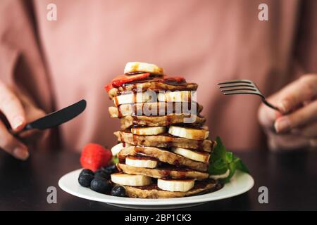 Pfannkuchen mit Bananenschokolade und Erdbeeren. Stapel von leckeren Pfannkuchen. Zucker Bombe, Kohlenhydrate Essen, süße Frühstück Pfannkuchen Stockfoto